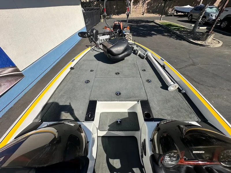 Slide: The Image of 2004 Triton Tr-20XDC boat deck with seating and controls, parked outdoors. - 22