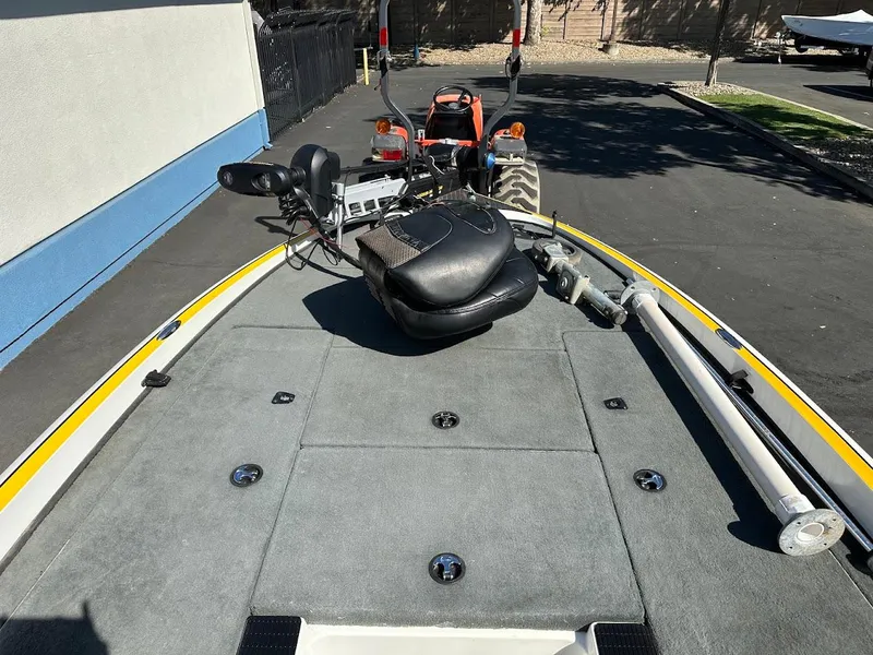 Slide: The Image of 2004 Triton Tr-20XDC boat deck with seating and equipment, parked outdoors. - 23