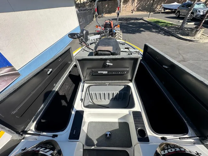 Slide: The Image of 2004 Triton Tr-20XDC boat interior with open storage compartments and seating area. - 28