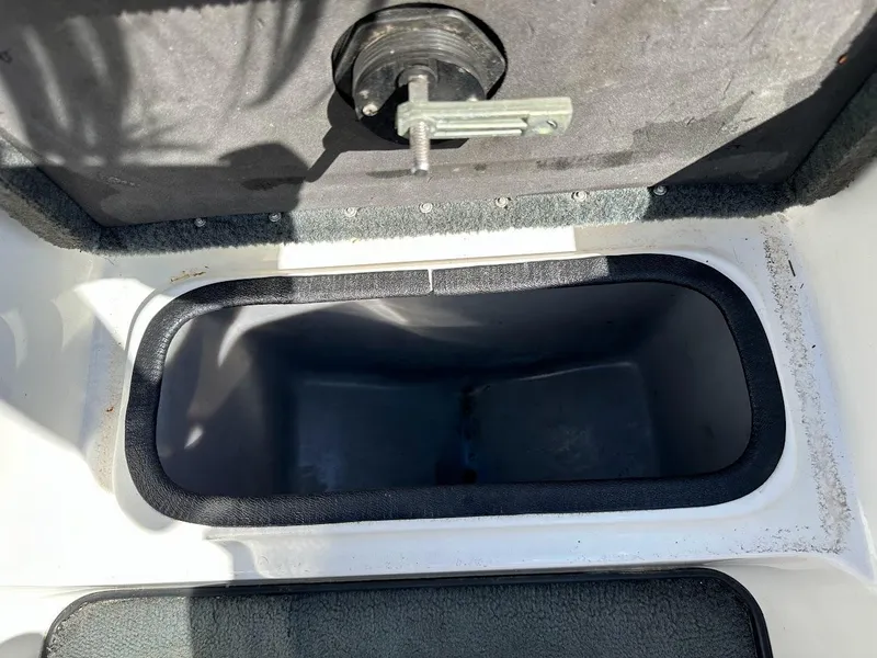 Slide: The Image of 2004 Triton Tr-20XDC boat storage compartment with latch, open and empty. - 31