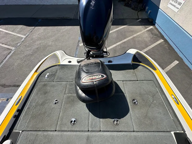 Slide: The Image of 2004 Triton Tr-20XDC boat deck with motor and seat, parked in a lot. - 32