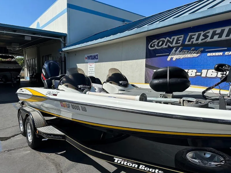 Slide: The Image of 2004 Triton Tr-20XDC boat parked at a marine dealership. - 5