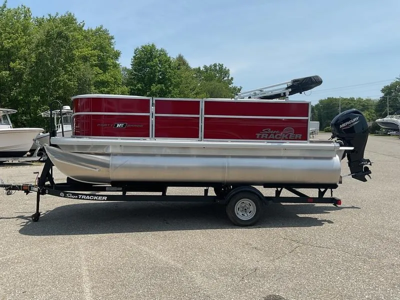 Slide: The Image of 2026 Sun Tracker PB 16 DLX pontoon boat on trailer, parked outdoors. - 4