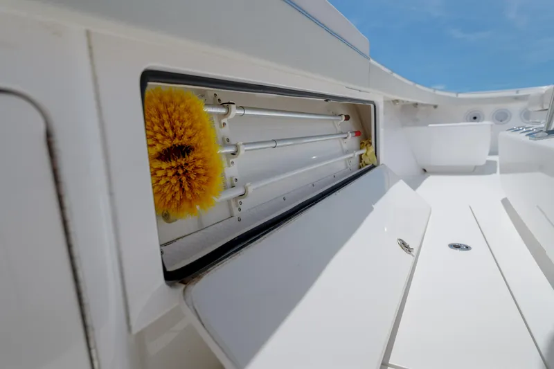 Slide: The Image of 2022 Valhalla V41 boat storage compartment with cleaning brush, open on deck. - 36