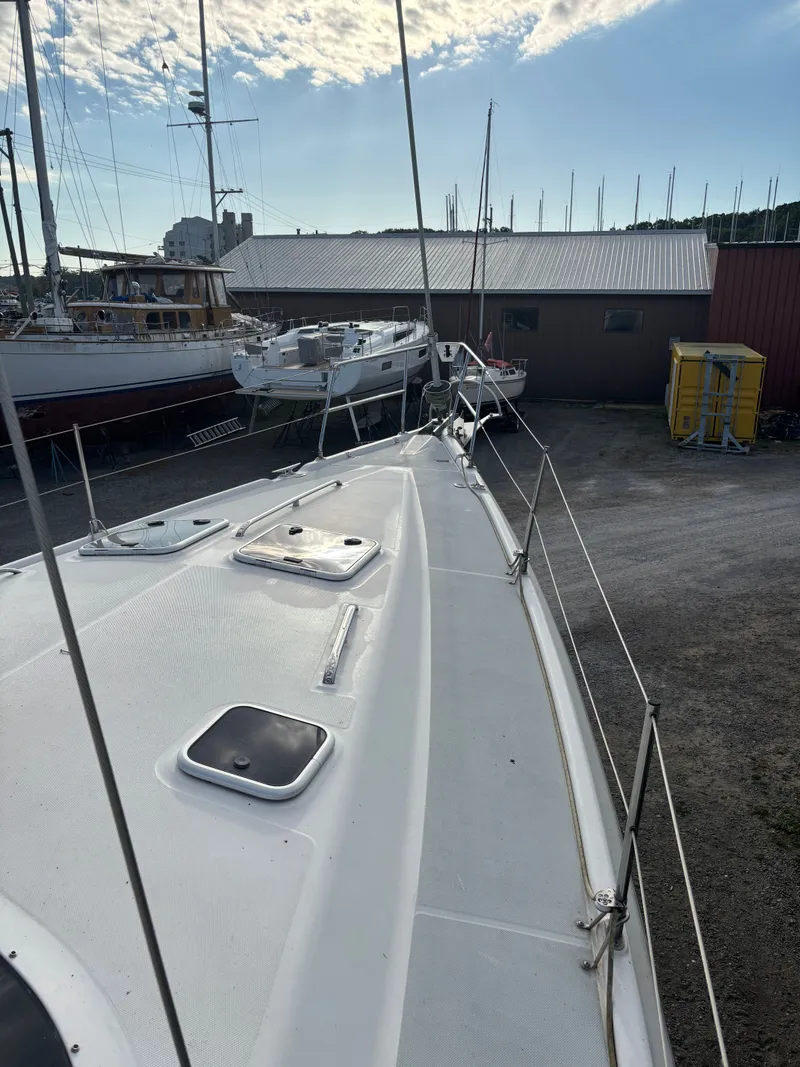 Slide: The Image of Sailboat deck view, Hunter 460, 2001 model, docked near other boats under a cloudy sky. - 13