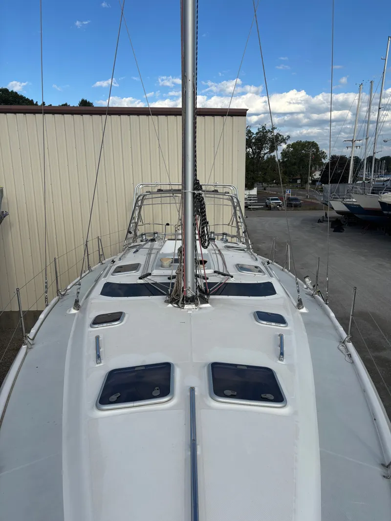 Slide: The Image of 2001 Hunter 460 sailboat deck with mast, docked at marina under blue sky. - 20