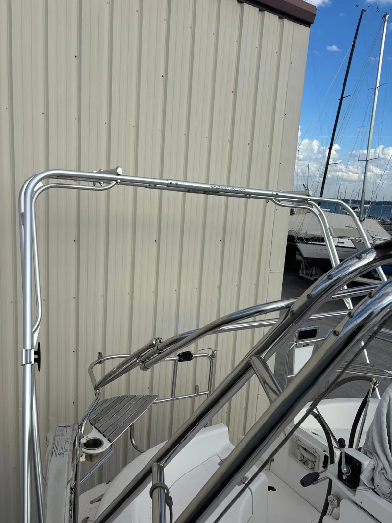 Slide: The Image of Stainless steel frame on a 2001 Hunter 460 sailboat, docked near a beige building. - 44