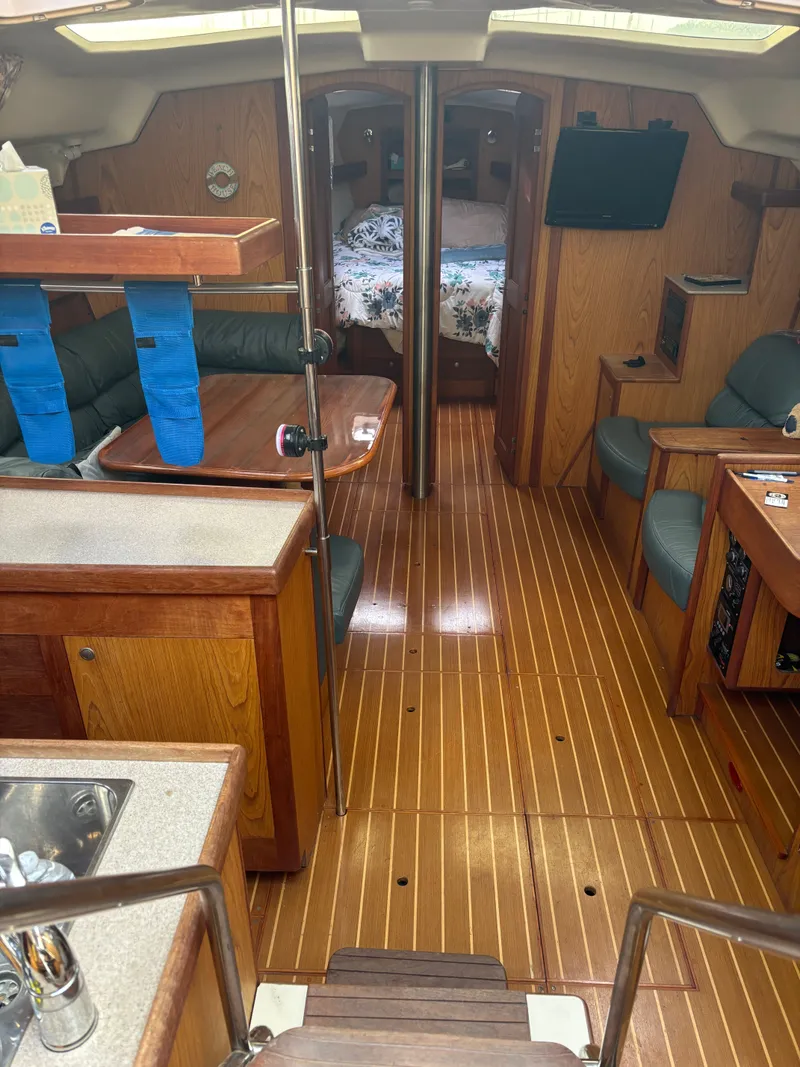 Slide: The Image of Interior of a 2001 Hunter 460 sailboat with wood flooring and cozy seating. - 49