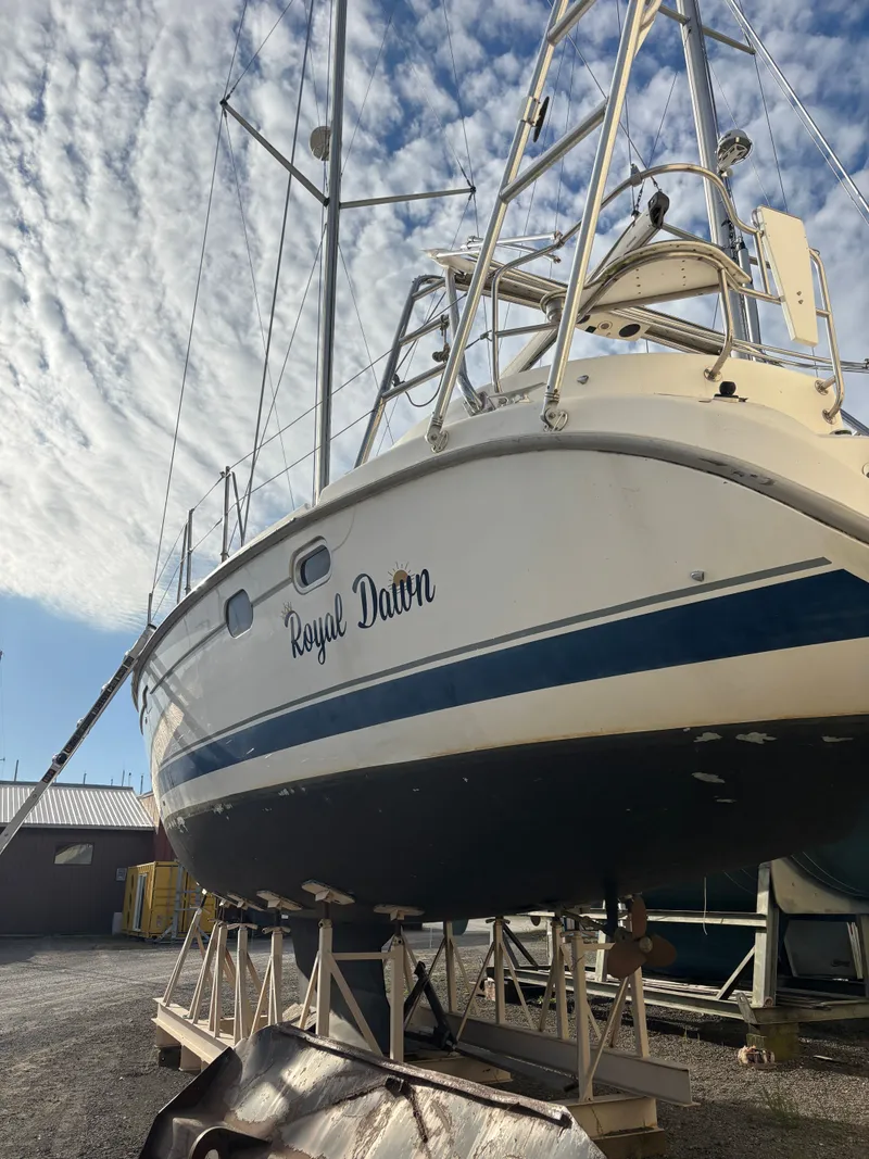 Slide: The Image of 2001 Hunter 460 sailboat "Royal Dawn" on dry dock under a cloudy sky. - 5