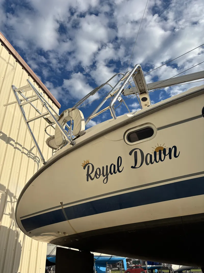 Slide: The Image of 2001 Hunter 460 sailboat "Royal Dawn" under clear sky near a building. - 6