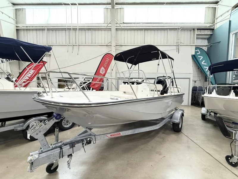 The Image of 2025 Boston Whaler 170 Montauk boat on trailer in showroom with banners. - 0