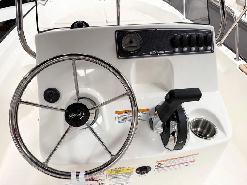 Slide: The Image of 2025 Boston Whaler 170 Montauk boat console with steering wheel and controls. - 6