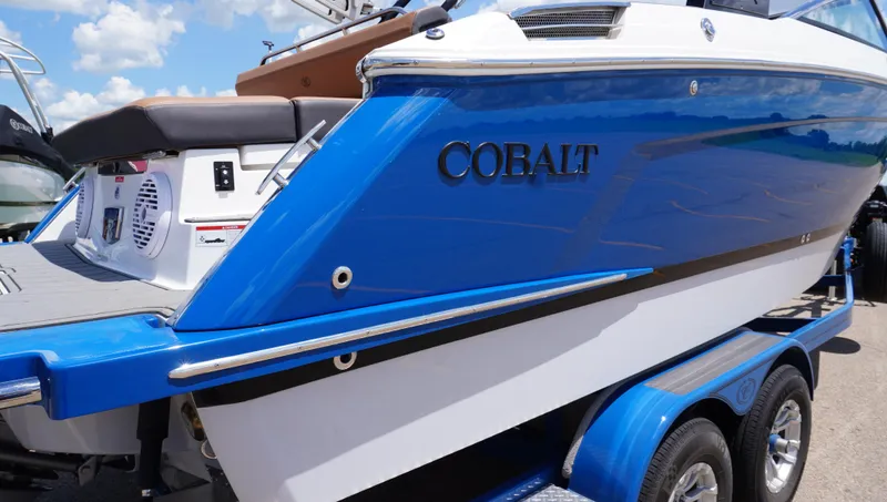 Slide: The Image of 2022 Cobalt R6 boat in blue and white on a trailer under a sunny sky. - 10