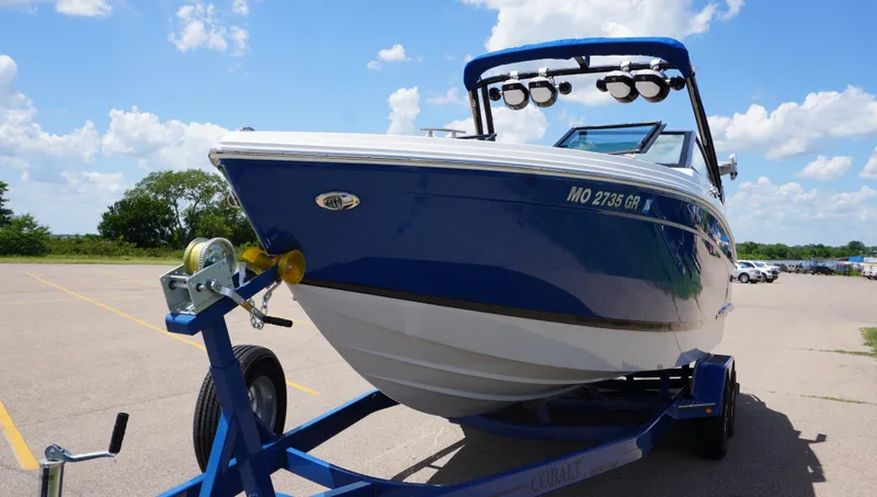 Slide: The Image of 2022 Cobalt R6 boat on trailer under blue sky in parking lot. - 3