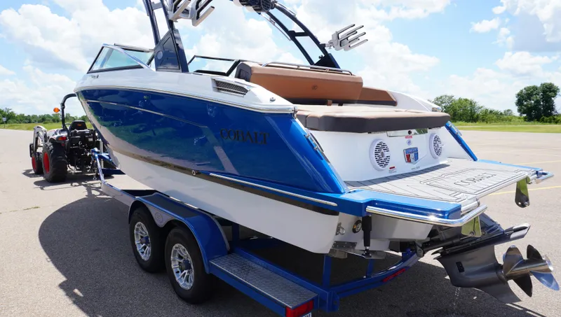 Slide: The Image of 2022 Cobalt R6 boat on trailer, blue and white design, parked outdoors. - 6