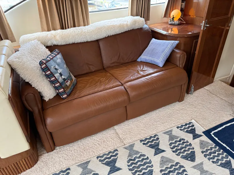 Slide: The Image of Luxurious interior of 2007 Carver 40 Motor Yacht with brown leather sofa and decorative pillows. - 11