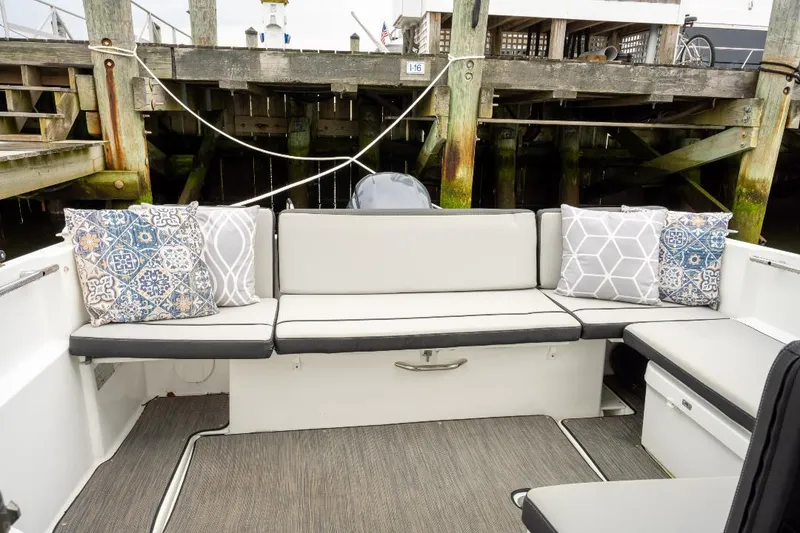 Slide: The Image of Jeanneau NC Weekender 795 Series 2 boat interior with cushioned seating and decorative pillows, 2021 model. - 10