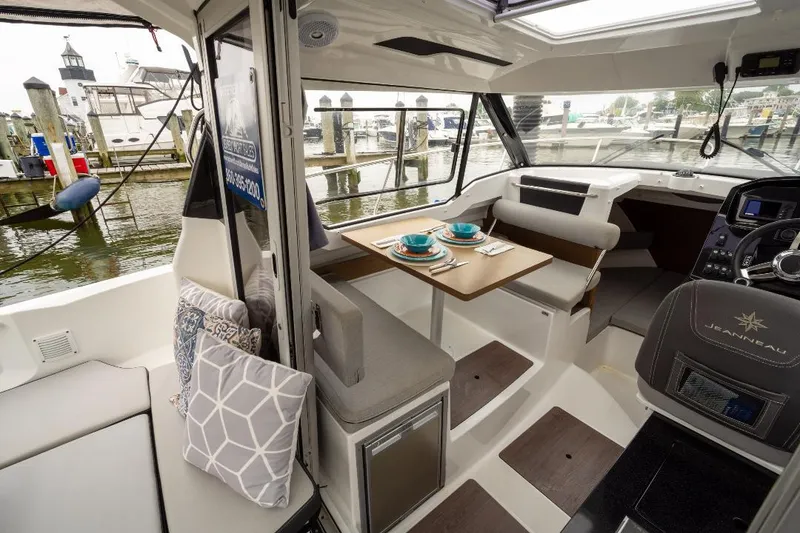 Slide: The Image of Interior of 2021 Jeanneau NC Weekender 795 Series 2 boat, featuring dining area and helm. - 11