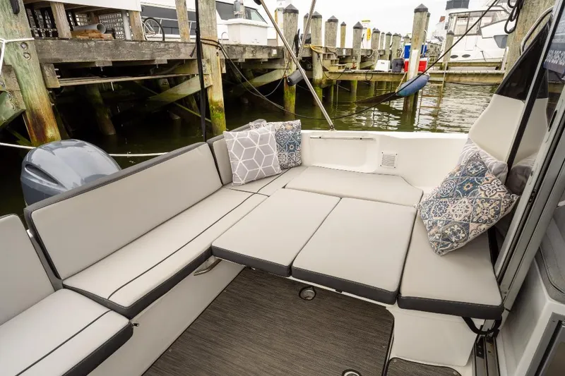 Slide: The Image of 2021 Jeanneau NC Weekender 795 Series 2 boat interior with cushioned seating and decorative pillows. - 12