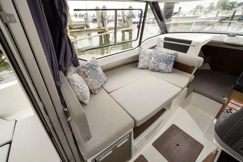 Slide: The Image of Interior of 2021 Jeanneau NC Weekender 795 Series 2 with cozy seating and decorative pillows. - 14