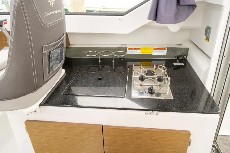 Slide: The Image of Compact kitchen area on Jeanneau NC Weekender 795 Series 2 boat, featuring stove and storage. - 16