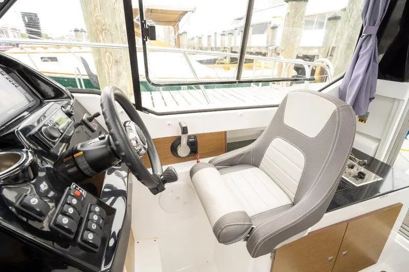 Slide: The Image of Interior helm of 2021 Jeanneau NC Weekender 795 Series 2 boat, featuring steering wheel and controls. - 23