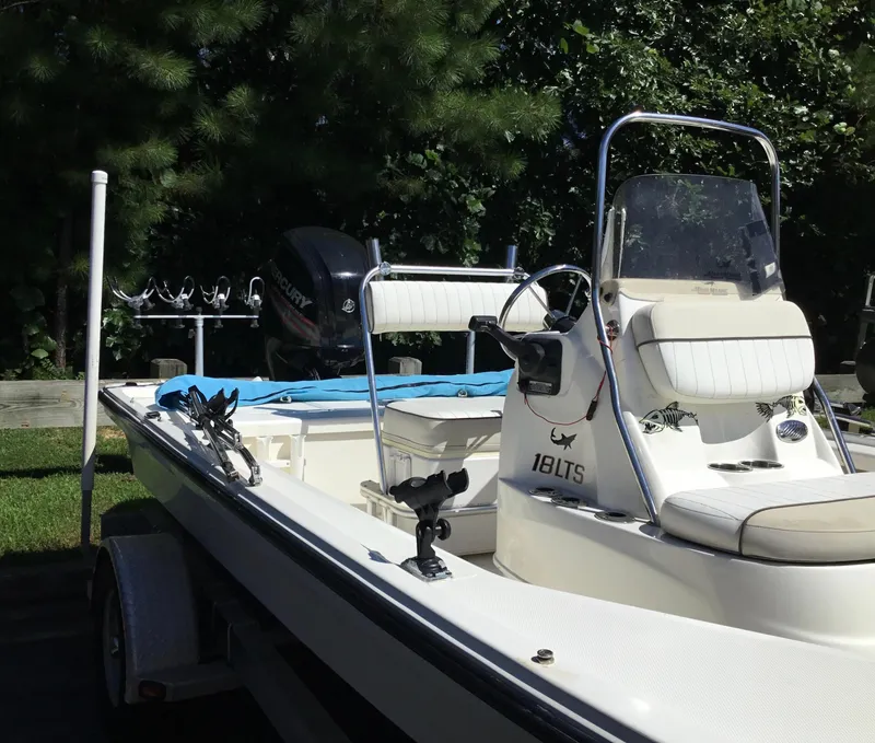 Slide: The Image of 2015 Mako 18 LTS boat with seating and fishing rod holders, parked outdoors. - 9