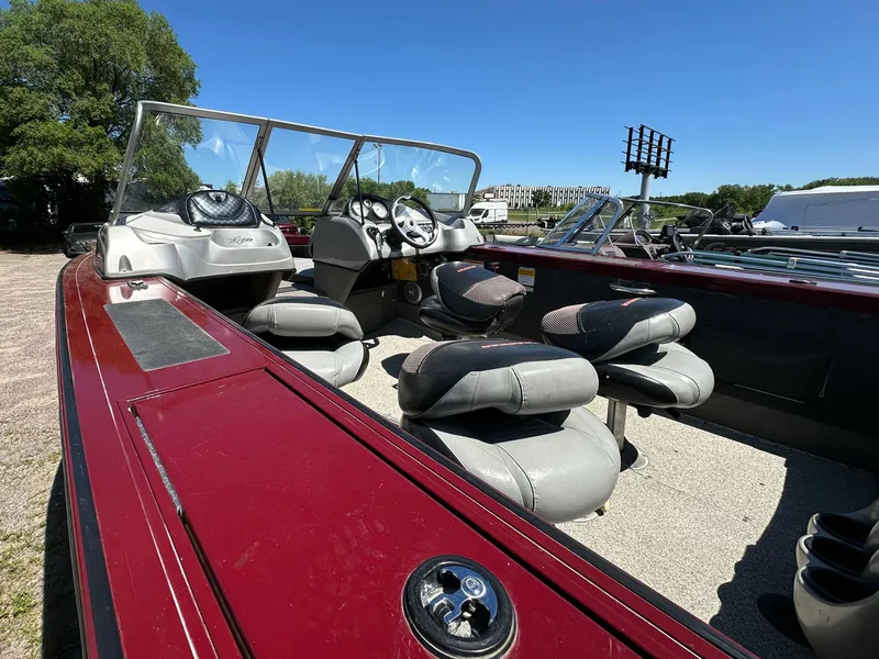 Slide: The Image of 2011 Tracker Targa V-18 Combo boat with seating, steering wheel, and windshield, parked outdoors. - 12