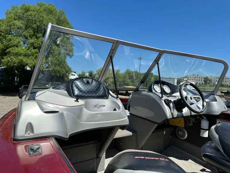 Slide: The Image of 2011 Tracker Targa V-18 Combo boat interior with steering wheel and dashboard under clear blue sky. - 13