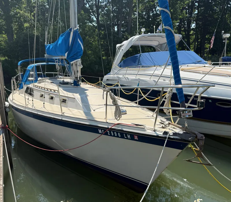 Slide: The Image of 1982 O'Day 34 sailboat docked, featuring blue and white design with covered sails. - 0