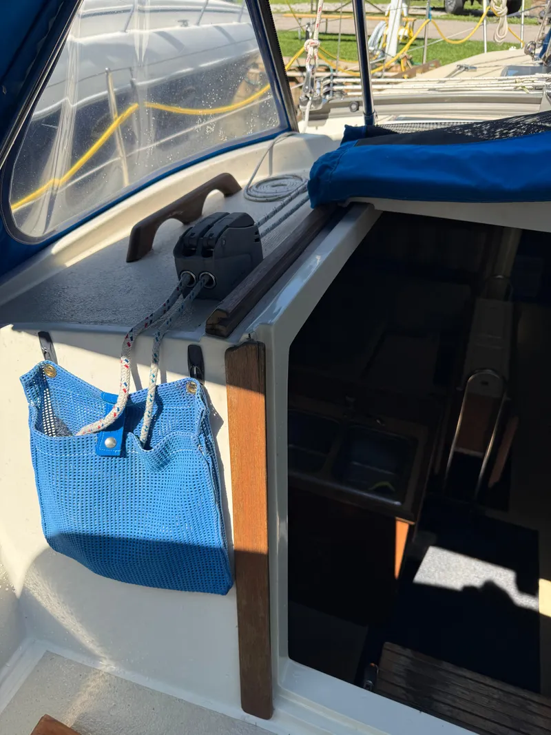 Slide: The Image of 1982 O'Day 34 sailboat cockpit with blue storage bag and cabin entrance. - 16