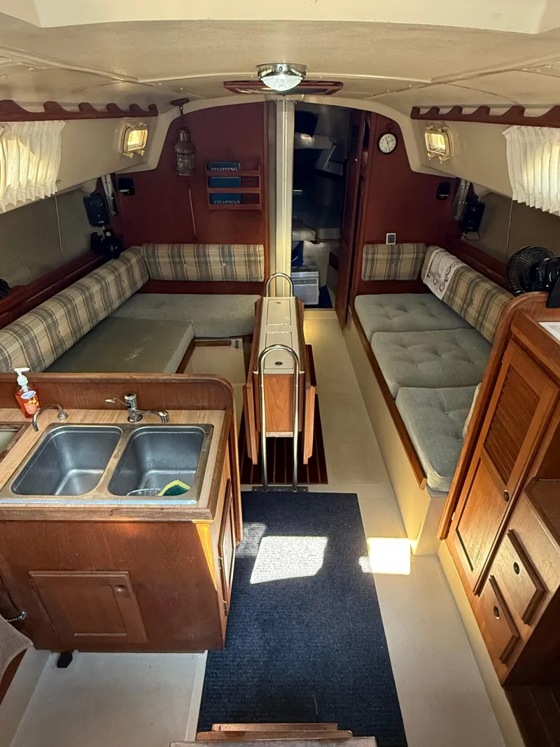 Slide: The Image of Interior of a 1982 O'Day 34 sailboat with cozy seating and a compact kitchen. - 18