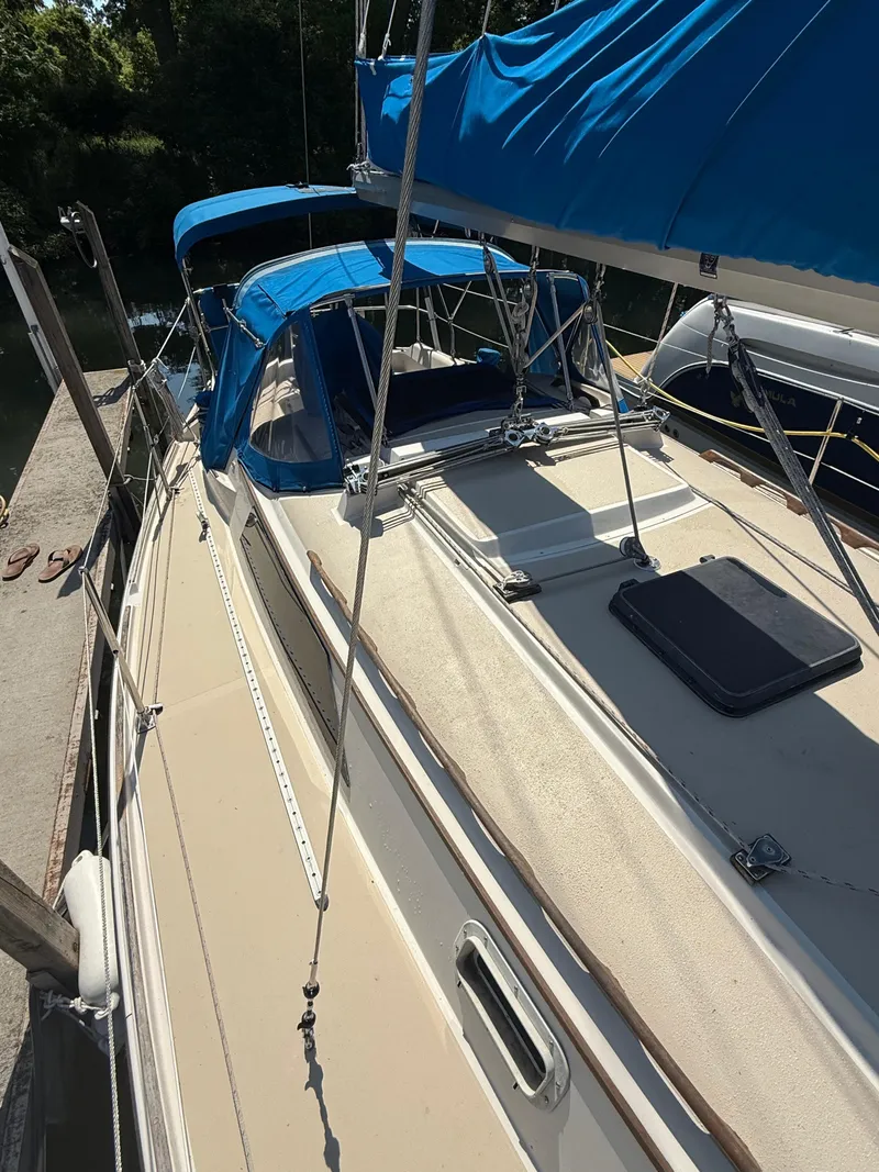Slide: The Image of 1982 O'Day 34 sailboat with blue canopy docked in a marina. - 2