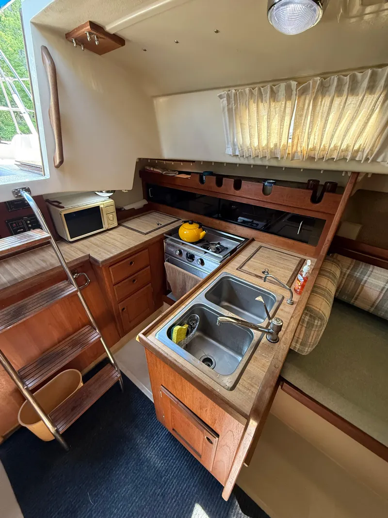 Slide: The Image of 1982 O'Day 34 sailboat interior kitchen with stove, sink, and microwave. - 25