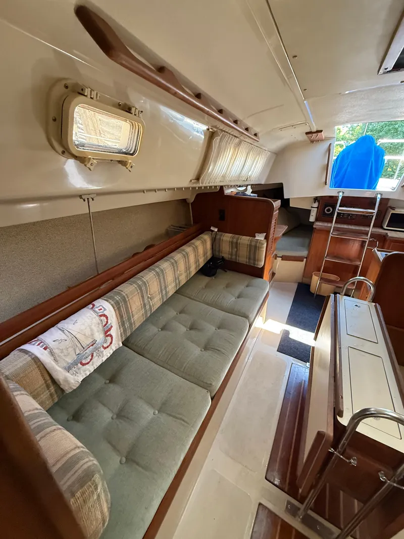Slide: The Image of Interior of 1982 O'Day 34 sailboat with cushioned seating and wooden cabinetry. - 26