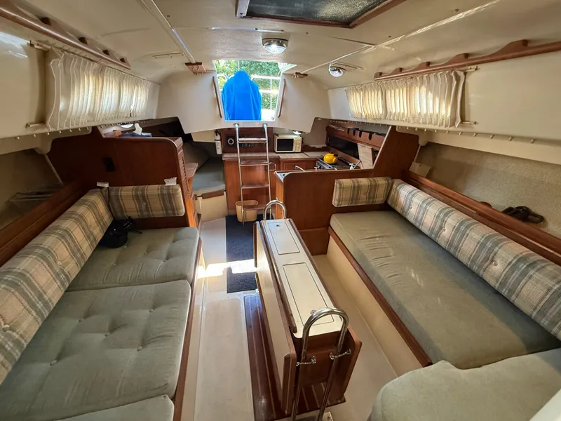 Slide: The Image of Interior of 1982 O'Day 34 sailboat with cozy seating and wooden cabinetry. - 27