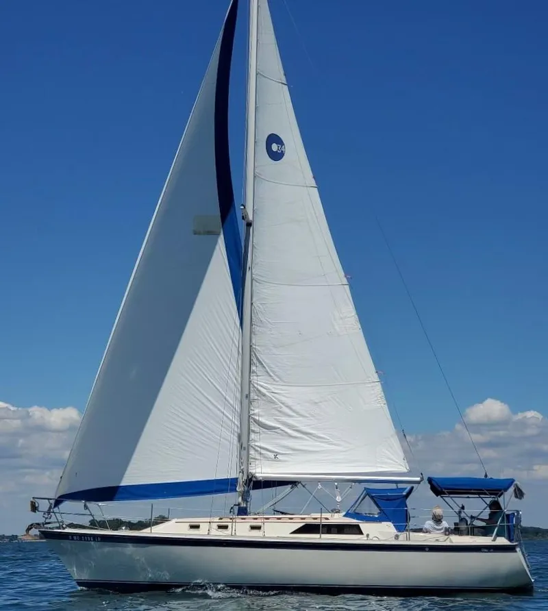 Slide: The Image of 1982 O'Day 34 sailboat with white sails on a clear blue day. - 34