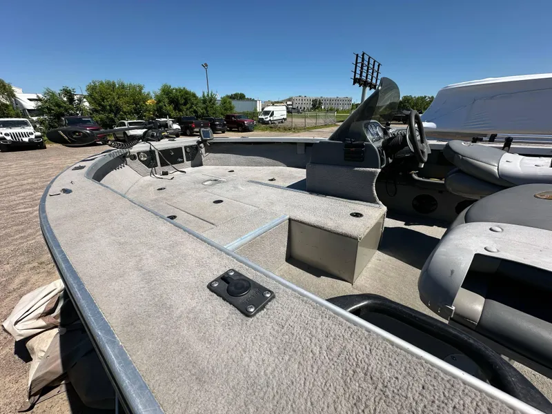 Slide: The Image of 2005 G3 1875 boat interior with steering console and seating, parked outdoors. - 13