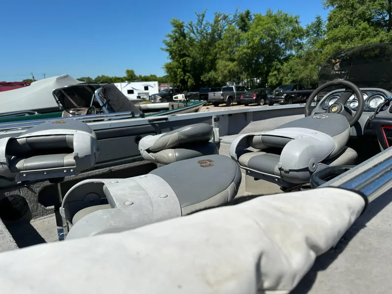 Slide: The Image of 2005 G3 1875 boat interior with gray seats and steering wheel, parked outdoors. - 21