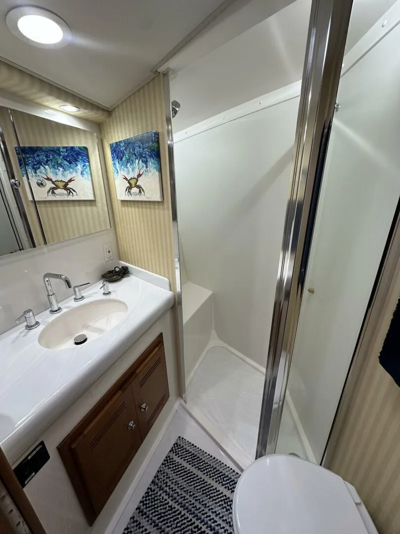 Slide: The Image of Luxurious bathroom in 2006 Cabo 48 Convertible yacht with shower, sink, and artwork. - 12