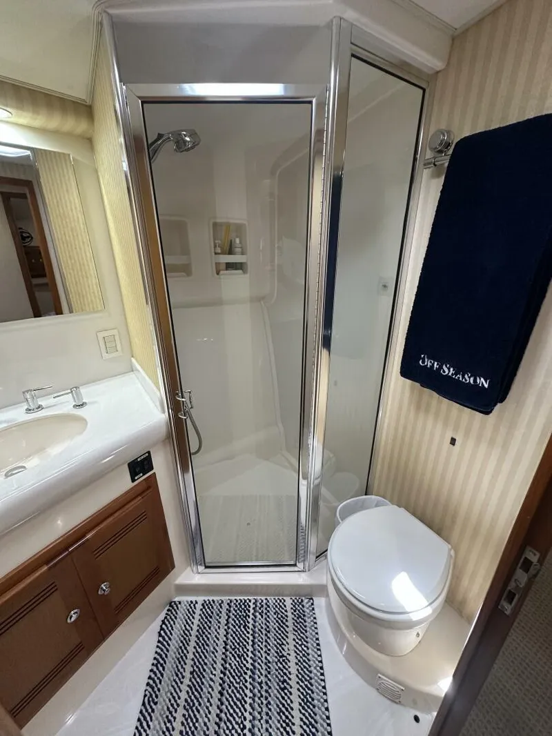 Slide: The Image of Luxurious bathroom in 2006 Cabo 48 Convertible yacht with shower, sink, and toilet. - 14