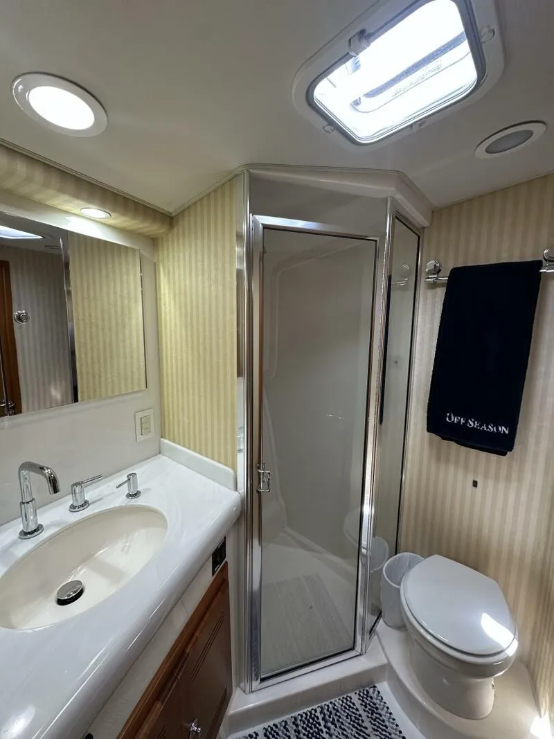 Slide: The Image of Luxurious bathroom in 2006 Cabo 48 Convertible yacht with shower, sink, and toilet. - 16