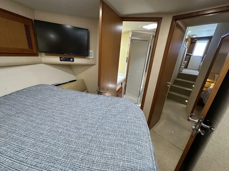 Slide: The Image of Interior of 2006 Cabo 48 Convertible yacht with bed, TV, and bathroom. - 18