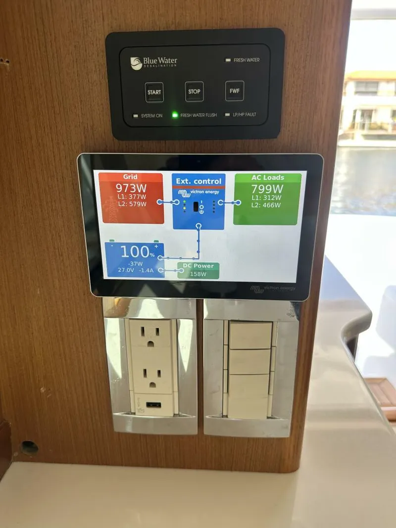 Slide: The Image of Control panel on 2006 Cabo 48 Convertible yacht displaying power usage and outlets. - 21