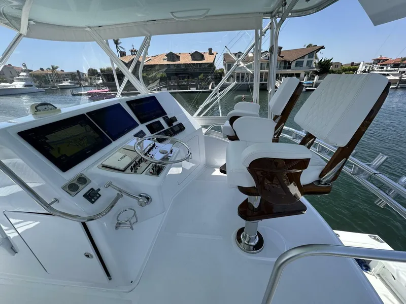 Slide: The Image of Helm of 2006 Cabo 48 Convertible yacht with dual captain chairs and navigation screens. - 25