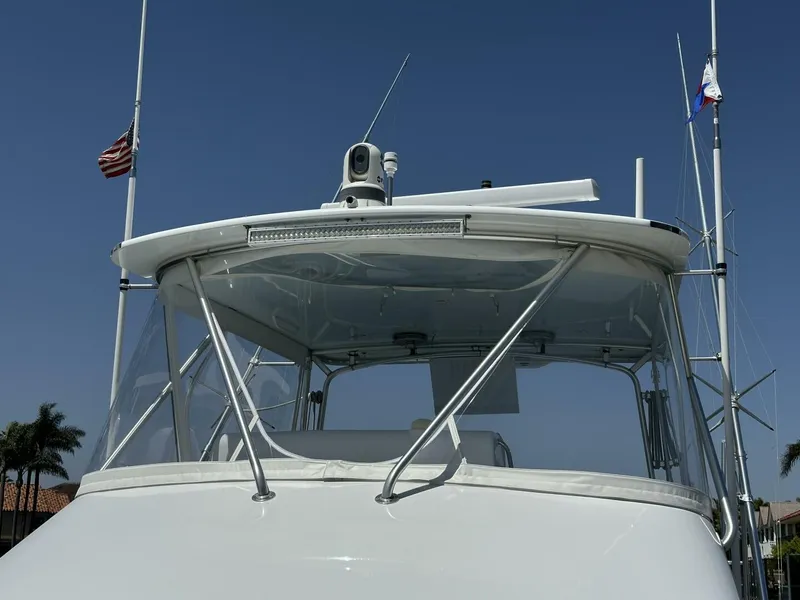Slide: The Image of 2006 Cabo 48 Convertible yacht with radar and antennas against clear blue sky. - 26