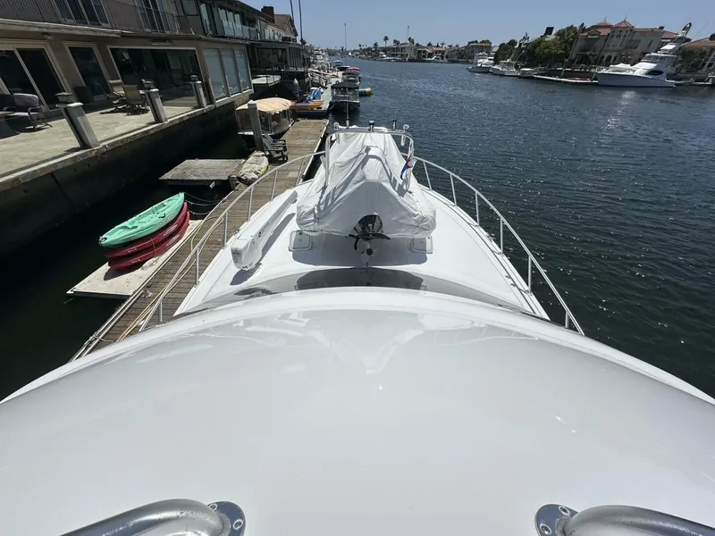 Slide: The Image of 2006 Cabo 48 Convertible yacht docked in a scenic marina. - 27