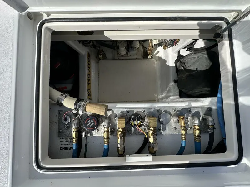 Slide: The Image of Engine compartment of a 2006 Cabo 48 Convertible boat, showing various pipes and fittings. - 30