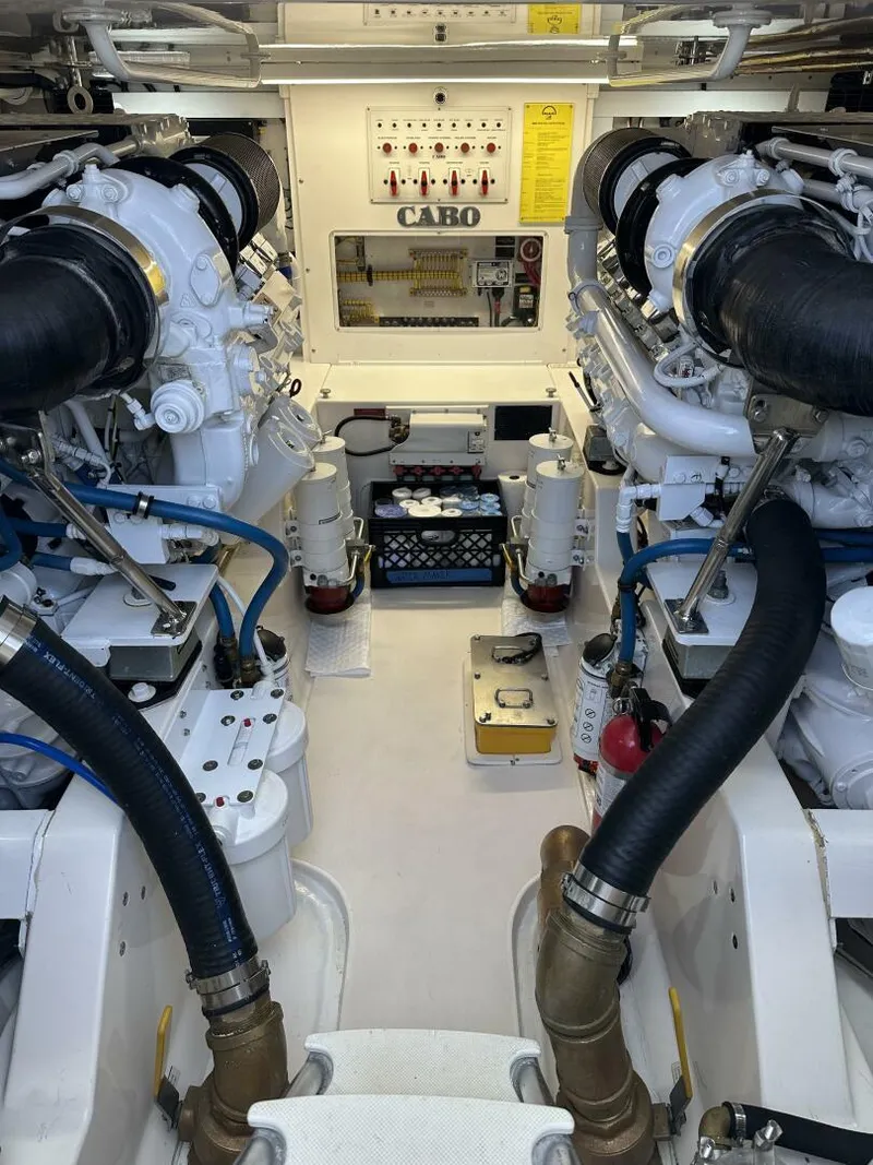 Slide: The Image of Engine room of a 2006 Cabo 48 Convertible yacht, showcasing dual engines and control panel. - 33