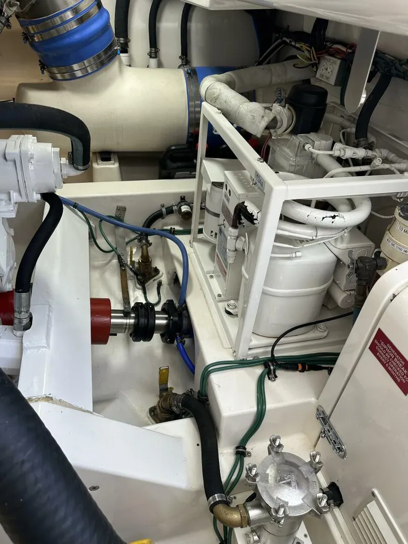 Slide: The Image of Engine room of a 2006 Cabo 48 Convertible yacht, showcasing mechanical components and piping. - 34